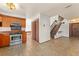Inviting living room featuring tile flooring, staircase, and a seamless transition to the kitchen space at 1450 Harbour Dr, Longwood, FL 32750