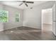 Bedroom with wood-look floors, ceiling fan and natural light through two windows at 1506 37Th St, Orlando, FL 32839