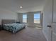 Bright bedroom with two windows, neutral carpet, and fresh paint at 15098 Windflower Aly, Winter Garden, FL 34787