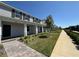 Exterior view of a two-story townhome with a covered porch, featuring gray siding and manicured landscaping at 15098 Windflower Aly, Winter Garden, FL 34787