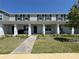 Charming two-story townhome features a landscaped yard, covered porch with columns and brick walkway at 15098 Windflower Aly, Winter Garden, FL 34787