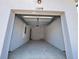Open garage with an interior view of a white painted space and concrete flooring at 15098 Windflower Aly, Winter Garden, FL 34787