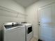 A laundry room is equipped with washer, dryer, and storage shelf at 15098 Windflower Aly, Winter Garden, FL 34787