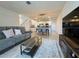Inviting living room with a comfortable gray sofa, patterned rug, and an open view to the kitchen at 15098 Windflower Aly, Winter Garden, FL 34787