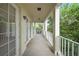 A covered balcony with white railing overlooks lush trees and has access through beautiful french doors at 1630 Common Way Rd # 303, Orlando, FL 32814