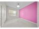 Bright bedroom with pink accent wall, neutral carpeting, and a window at 1630 Common Way Rd # 303, Orlando, FL 32814