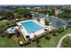 Aerial view of a pristine community pool with ample lounge chairs and lush landscaping surrounding the amenity at 1630 Common Way Rd # 303, Orlando, FL 32814
