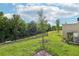 Green backyard with black metal fencing, privacy fence, and tree line at 16447 Bird Of Paradise Ave, Clermont, FL 34714