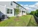A view of the backyard and the home's exterior with the siding, windows, and backyard at 16447 Bird Of Paradise Ave, Clermont, FL 34714