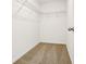 Walk-in closet featuring neutral carpet, white walls, and wire shelving at 16447 Bird Of Paradise Ave, Clermont, FL 34714