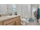 Cozy bathroom with a stylish vanity, toilet, and a shower with patterned curtains at 17106 Guilford Ct, Orlando, FL 32820