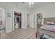 Teen bedroom with open closet, wood-look tile floor, and open doorway to additional rooms at 17106 Guilford Ct, Orlando, FL 32820