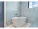 Bathroom boasting a pristine soaking tub beneath a window, complemented by elegant tile and fixtures at 18026 Reynolds Pkwy, Orlando, FL 32833