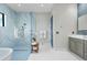 Modern bathroom features a spacious glass shower with premium fixtures, a soaking tub, and blue accent tiles at 18026 Reynolds Pkwy, Orlando, FL 32833