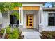 Contemporary home entrance with yellow door, stone accents, modern lighting, and curated landscaping at 18026 Reynolds Pkwy, Orlando, FL 32833
