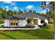Inviting single-story home featuring white exterior, yellow front door, well-manicured lawn, and lush landscaping at 18026 Reynolds Pkwy, Orlando, FL 32833