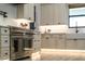 Well-equipped kitchen with stainless steel oven and cooktop, designer cabinets and drawers, and modern lighting at 18026 Reynolds Pkwy, Orlando, FL 32833