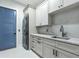 Bright laundry room features sleek white cabinetry, marble countertops, and stacked washer and dryer at 18026 Reynolds Pkwy, Orlando, FL 32833