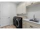 Well-organized laundry room with modern washer and dryer, ample cabinet space, and a sink at 18026 Reynolds Pkwy, Orlando, FL 32833