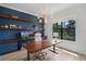 Stylish home office with custom built-ins, a large wooden desk, and backyard view at 18026 Reynolds Pkwy, Orlando, FL 32833