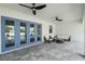 Spacious covered patio with outdoor seating and a view of the pool area with blue french doors at 18026 Reynolds Pkwy, Orlando, FL 32833