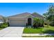 Charming single-story home features a well-manicured lawn, neutral exterior, and a two-car garage at 1918 Marabou Dr, Davenport, FL 33896