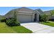 Charming single-story home features a well-manicured lawn, neutral exterior, and a two-car garage at 1918 Marabou Dr, Davenport, FL 33896