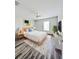 Bright bedroom with a light wood bed frame, white linens, and an eye-catching geometric rug at 2131 Nicollett Way, Leesburg, FL 34748