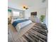 Inviting bedroom featuring a plush bed with blue accents, beach-themed wall decor, and ample natural light at 2131 Nicollett Way, Leesburg, FL 34748