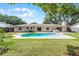 Beautiful backyard view of refreshing pool, patio, luscious lawn, and complementing exterior features of home at 2311 Huron Trl, Maitland, FL 32751