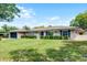 Charming single-story home featuring a well-maintained lawn, complemented by manicured hedges and blue shutters at 2311 Huron Trl, Maitland, FL 32751