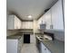 Bright kitchen featuring white cabinets, dark appliances, and light countertops at 2322 Vincent Rd, Orlando, FL 32817