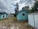 A blue shed stands in the backyard, complemented by other outbuildings, offering versatility and storage options at 2322 Vincent Rd, Orlando, FL 32817