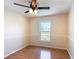 Bedroom with updated ceiling fan, hardwood floors, and large window at 241 Churchill Ct, Kissimmee, FL 34758