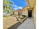 Inviting front entrance with a dark wood door, landscaping, and healthy lawn at 241 Churchill Ct, Kissimmee, FL 34758
