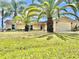 Charming one story home featuring an attached two-car garage and beautiful palm trees in a well maintained yard at 241 Churchill Ct, Kissimmee, FL 34758