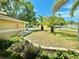 Landscaped front yard with mature palm trees, colorful plants, and a well-manicured lawn at 241 Churchill Ct, Kissimmee, FL 34758