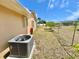 Side yard of a home featuring well-maintained grass and a fenced perimeter, along with an AC unit at 241 Churchill Ct, Kissimmee, FL 34758