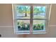 Bright view from inside looking out to a lush garden and palm trees at 241 Churchill Ct, Kissimmee, FL 34758