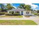 Charming single-story home with a well-manicured lawn, lush green bushes, and a blue front door at 2812 E Michigan St, Orlando, FL 32806