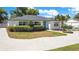 Charming single-story home with a well-manicured lawn, lush green bushes, and a blue front door at 2812 E Michigan St, Orlando, FL 32806