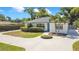 Charming single-story home with a well-manicured lawn, lush green bushes, and a blue front door at 2812 E Michigan St, Orlando, FL 32806