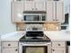 A view of the kitchen range with stainless steel appliances and decorative backsplash at 2850 Tremont Dr, Eustis, FL 32726