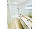 An open-concept bathroom with combined shower and tub, white tiled floors, and a large mirror over a sink at 315 Grand Magnolia Ave # 112, Celebration, FL 34747