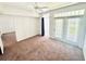 Bright bedroom with a ceiling fan, neutral carpet, and glass doors leading to an outdoor space at 315 Grand Magnolia Ave # 112, Celebration, FL 34747