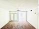 This is a well-lit living room with carpet and a door leading to the outside and another adjacent room at 315 Grand Magnolia Ave # 112, Celebration, FL 34747