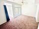 Spacious living room with brown carpet, a ceiling fan, and large glass doors leading to a balcony at 315 Grand Magnolia Ave # 112, Celebration, FL 34747