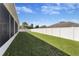 Backyard featuring a well-maintained lawn and white fence, creating a private outdoor space at 36300 Grand Island Oaks Cir, Grand Island, FL 32735