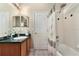 Full bathroom featuring a shower/tub combo, neutral tile, decorative shower curtain and sink with dark countertops at 36300 Grand Island Oaks Cir, Grand Island, FL 32735