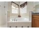 Close-up of the bathtub in the main bathroom with a tile surround and windows at 36300 Grand Island Oaks Cir, Grand Island, FL 32735